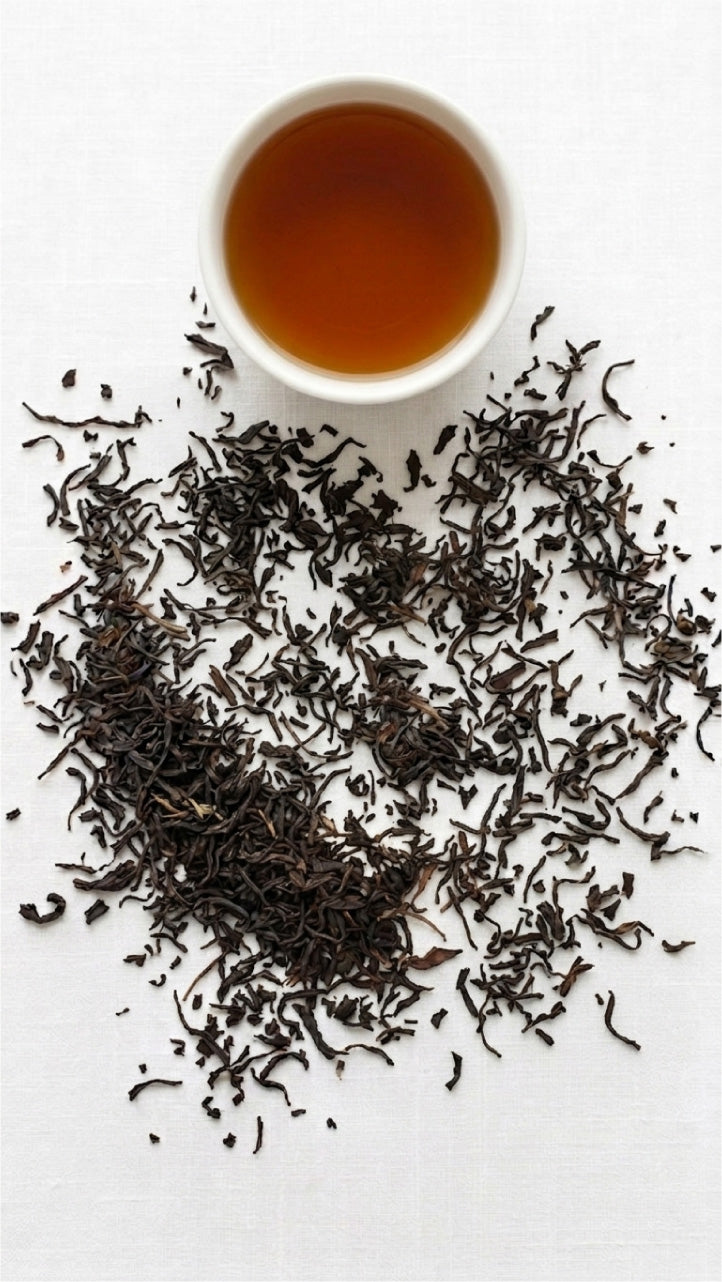 simple white tea cup with tea inside and scattered tea leaves on a white table